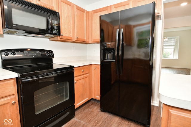 kitchen featuring black appliances and light hardwood / wood-style flooring