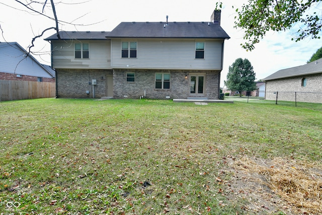 back of property featuring a lawn and a patio