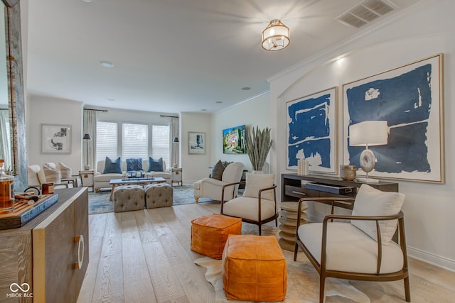 living room featuring ornamental molding and light wood-type flooring