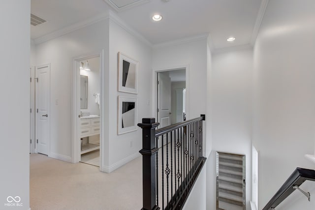 hallway with ornamental molding and light carpet