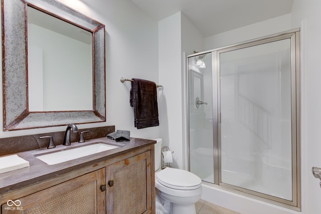 bathroom with tile patterned flooring, vanity, toilet, and walk in shower