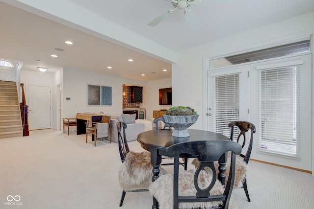 dining space featuring ceiling fan and light carpet