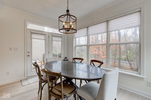 dining space with light hardwood / wood-style flooring, a chandelier, and ornamental molding