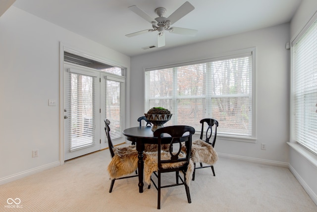 dining space featuring light colored carpet and ceiling fan