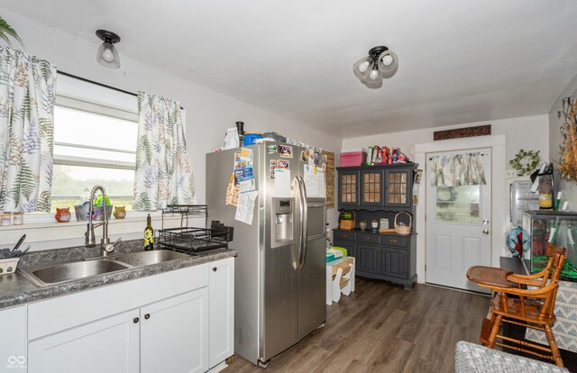 kitchen featuring dark hardwood / wood-style flooring, sink, stainless steel fridge with ice dispenser, and white cabinets