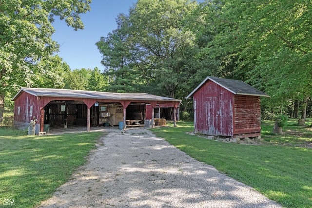 view of pole building with gravel driveway and a lawn