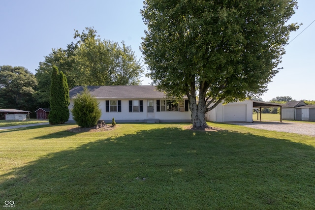 single story home with an outbuilding, a garage, a carport, and a front lawn