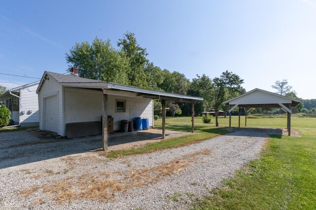 view of home's exterior with gravel driveway, a lawn, and a detached garage