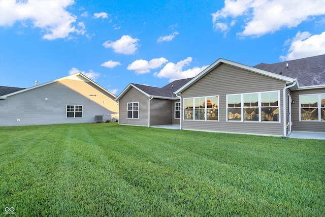 back of property with a patio area, cooling unit, and a lawn