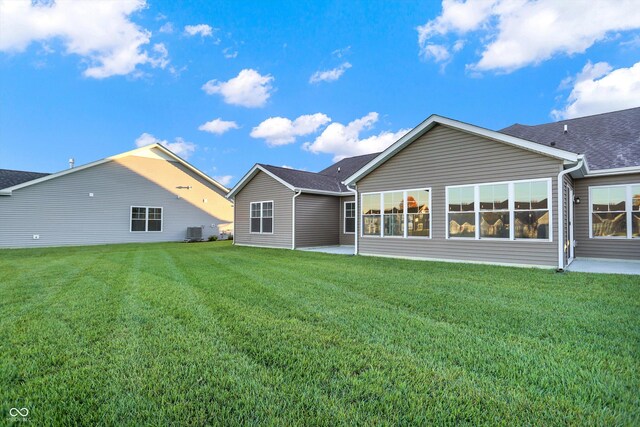 134 Maxim Ct, Cumberland, IN 46229 - back of property featuring a yard, central AC, a patio area, and roof with shingles