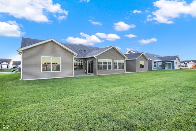 back of property with a sunroom and a lawn