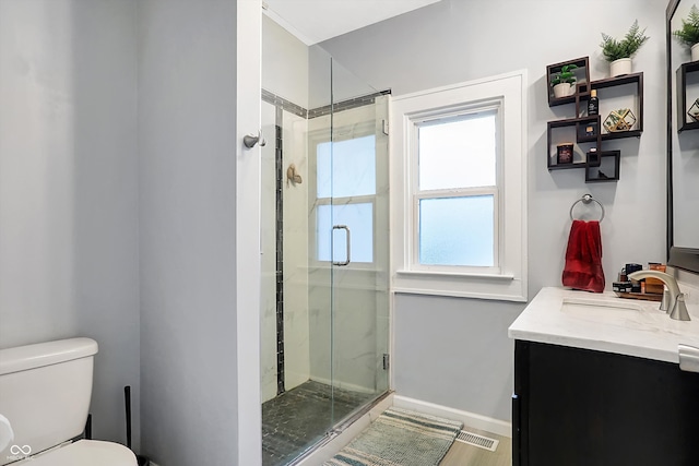 bathroom featuring vanity, toilet, an enclosed shower, and a healthy amount of sunlight