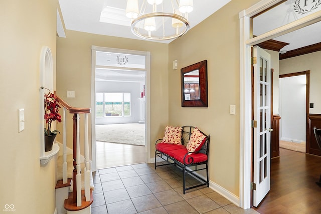 foyer with crown molding, light wood-type flooring, and a chandelier