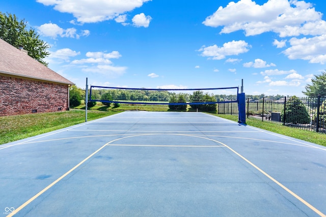 view of basketball court featuring basketball court, fence, volleyball court, and a lawn