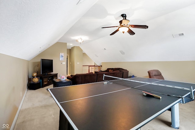 recreation room featuring lofted ceiling, ceiling fan, light carpet, and a textured ceiling