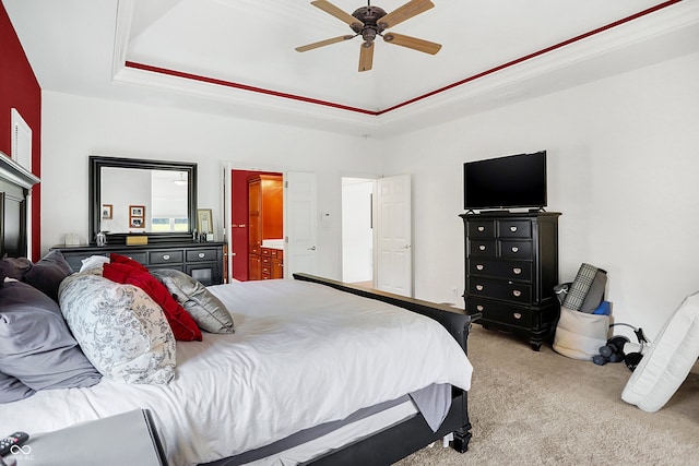 carpeted bedroom with ceiling fan, connected bathroom, and a raised ceiling