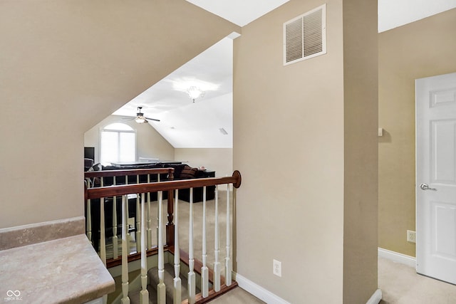 stairway with lofted ceiling, ceiling fan, visible vents, and baseboards