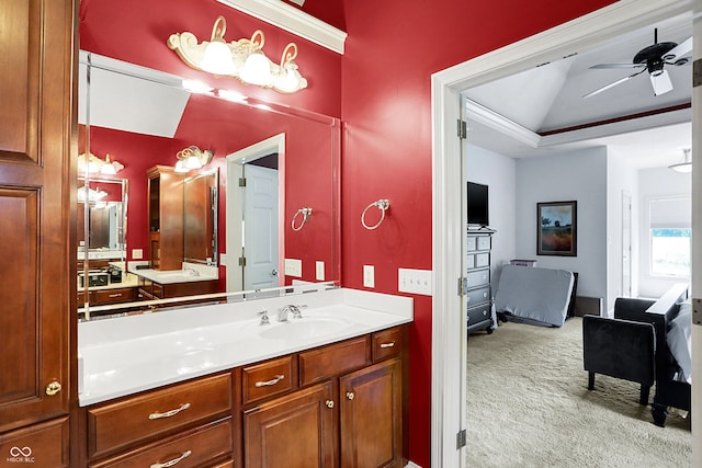 bathroom featuring ceiling fan, a raised ceiling, and vanity