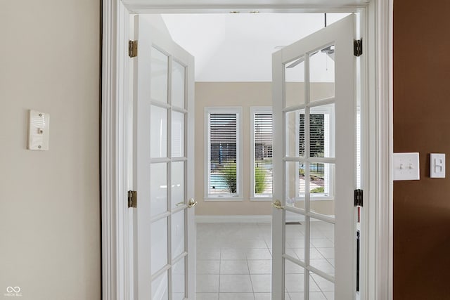 doorway featuring light tile patterned floors, french doors, and baseboards