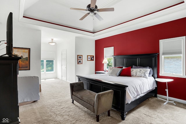 carpeted bedroom featuring crown molding, a raised ceiling, and ceiling fan