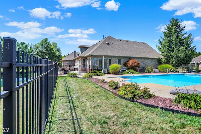 view of pool with a patio, a yard, fence, and a fenced in pool