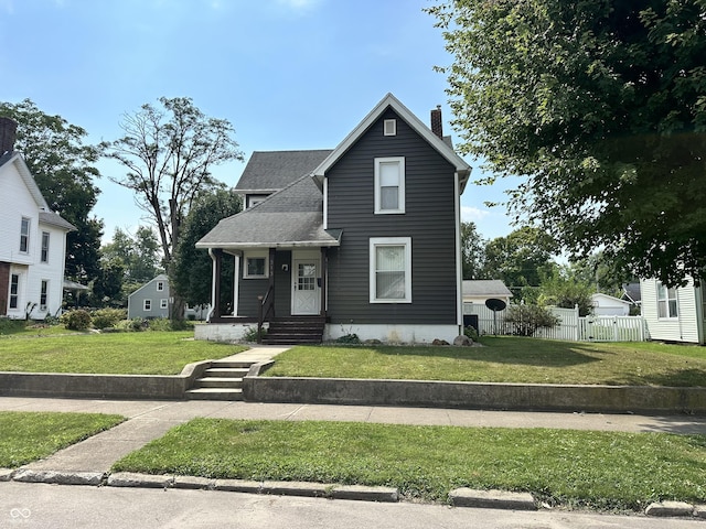 view of front facade with a chimney, fence, a front lawn, and roof with shingles