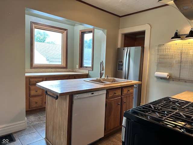 kitchen featuring white dishwasher, range with gas stovetop, stainless steel fridge with ice dispenser, an island with sink, and sink