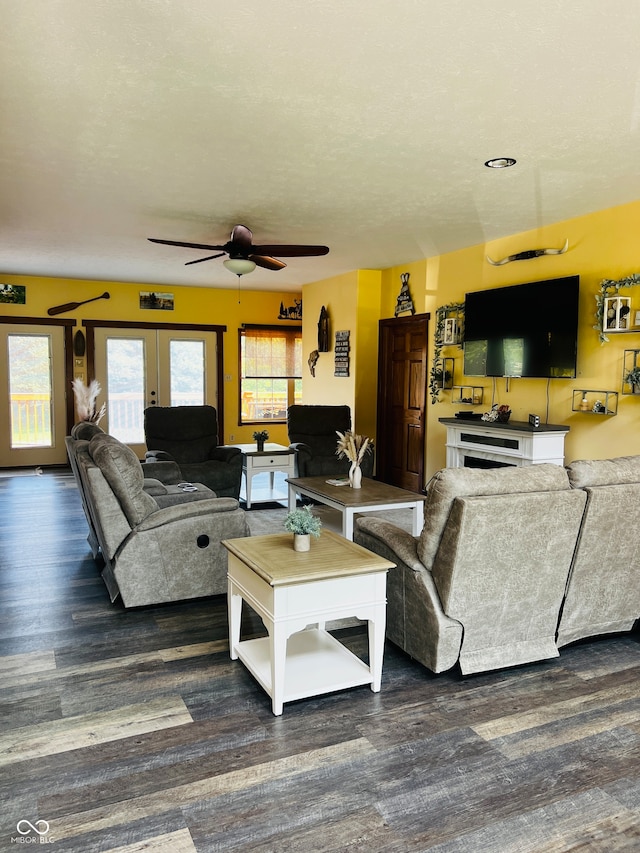 living room featuring dark wood-type flooring, ceiling fan, a textured ceiling, and french doors