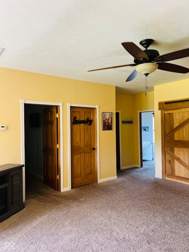 interior space with a textured ceiling, ceiling fan, and carpet floors