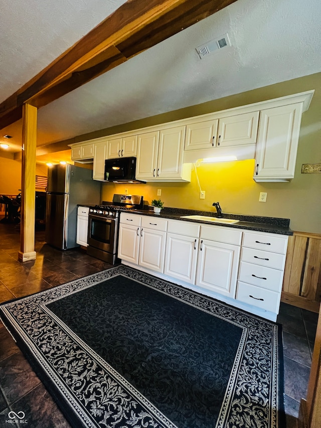 kitchen featuring a textured ceiling, sink, appliances with stainless steel finishes, and white cabinets