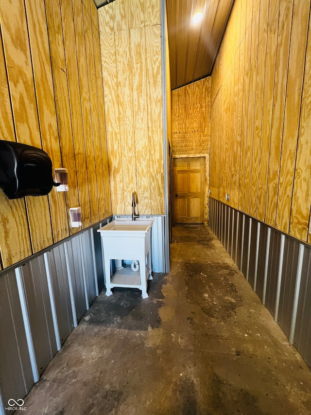 interior space featuring wooden walls and concrete floors