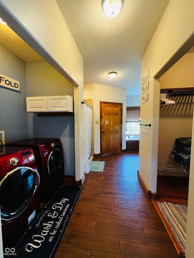 washroom with dark wood-type flooring, a textured ceiling, and washing machine and dryer