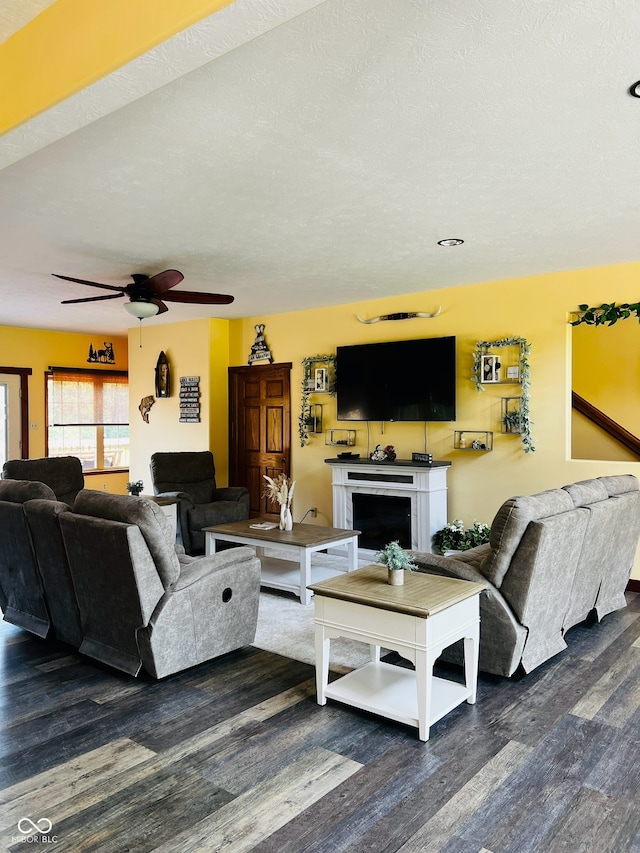 living room featuring a textured ceiling, ceiling fan, and dark hardwood / wood-style floors