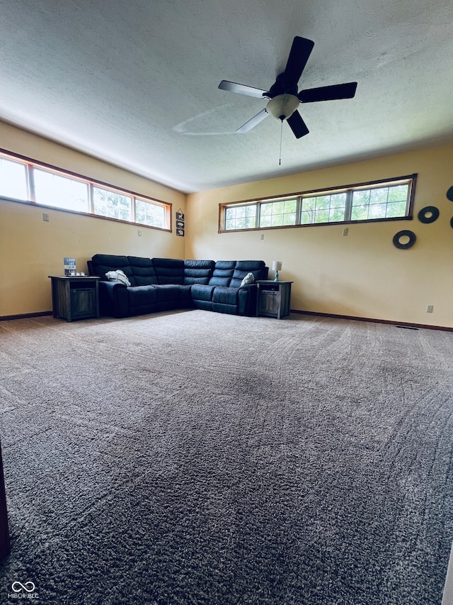 living room with a textured ceiling, a healthy amount of sunlight, ceiling fan, and carpet floors