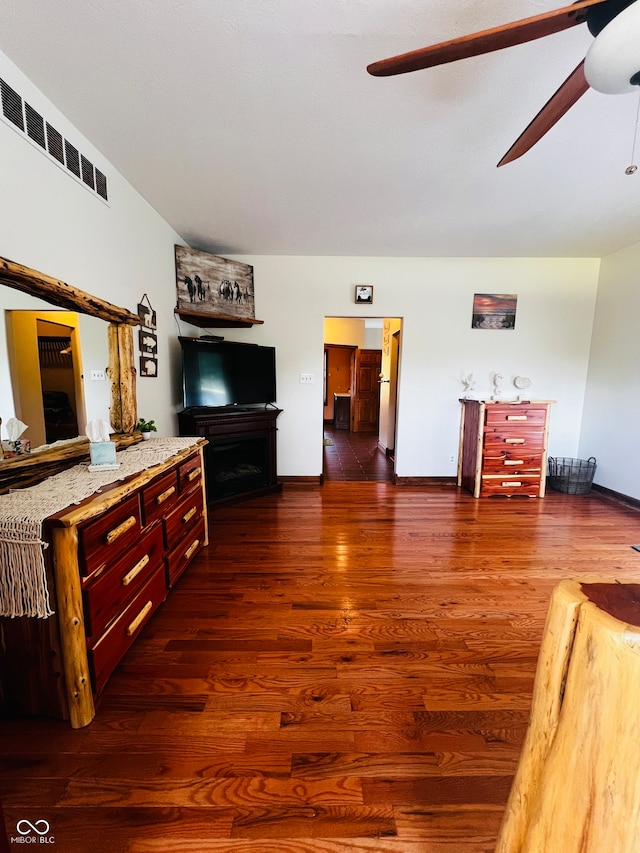 living room featuring dark wood-type flooring and ceiling fan