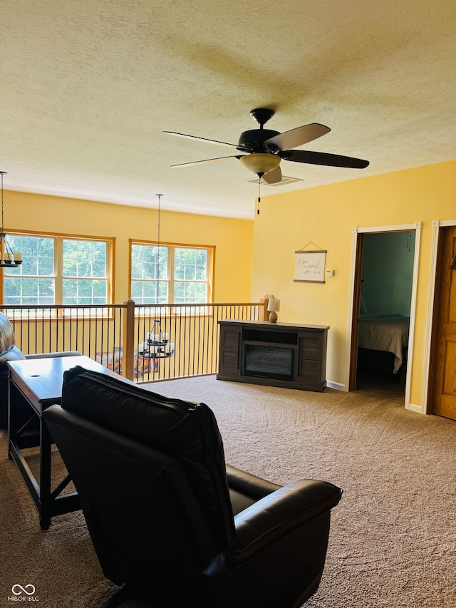 carpeted living room featuring a textured ceiling and ceiling fan