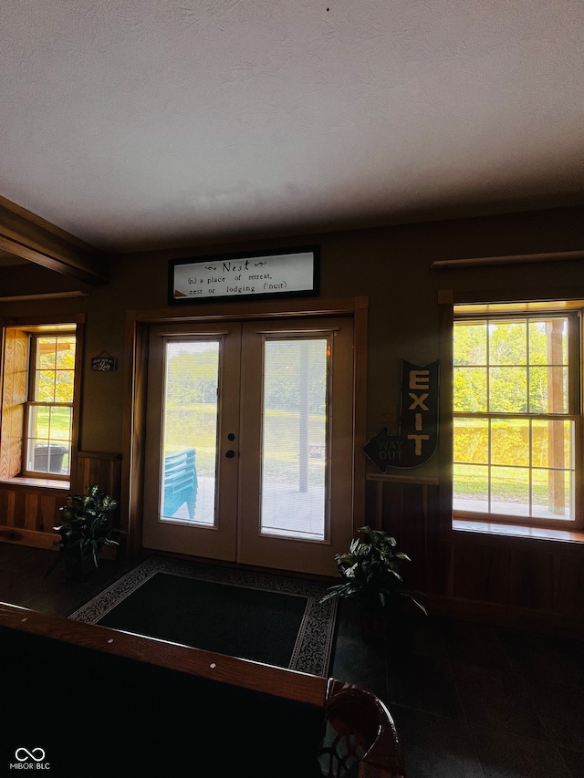 interior space featuring a wealth of natural light, french doors, and a textured ceiling