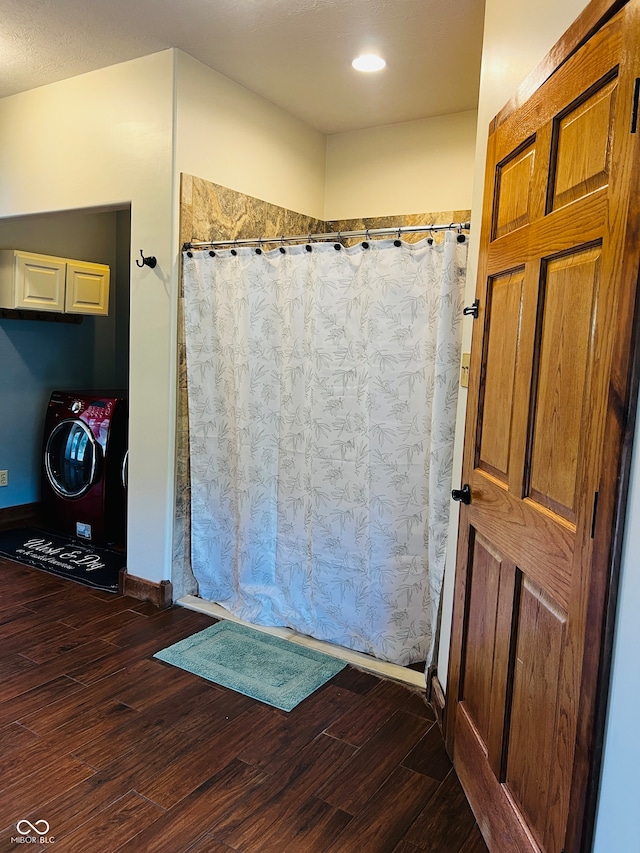 bathroom with a shower with curtain, wood-type flooring, and washing machine and clothes dryer