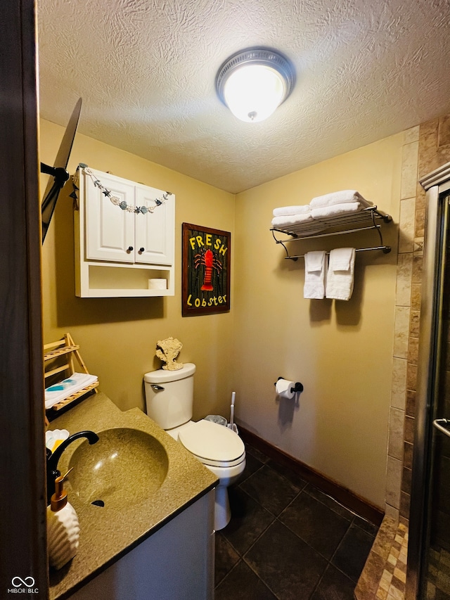 bathroom featuring tile patterned floors, toilet, a shower, vanity, and a textured ceiling