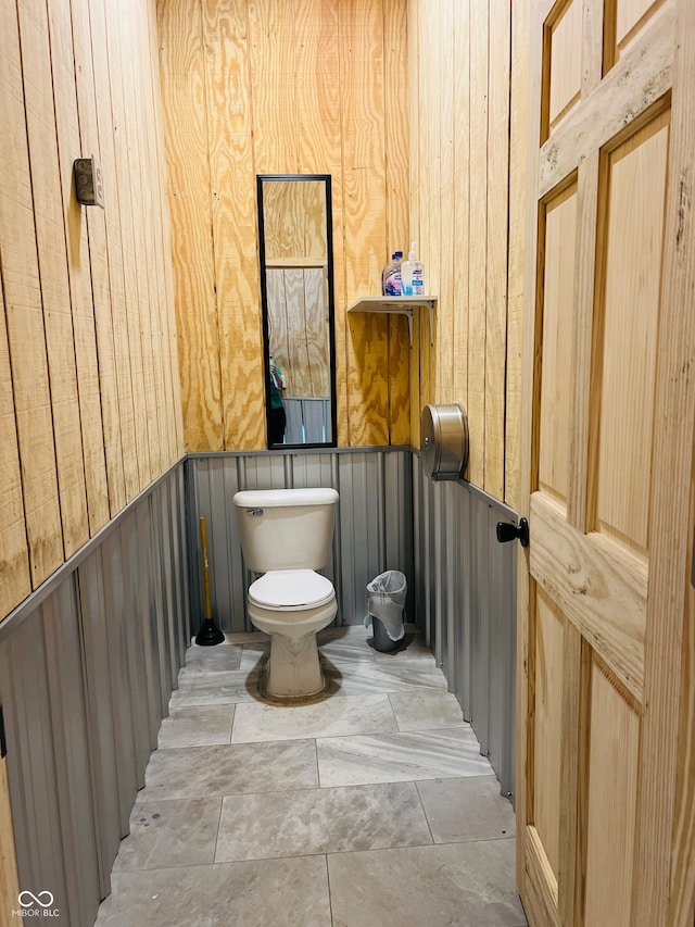 bathroom with wood walls and toilet