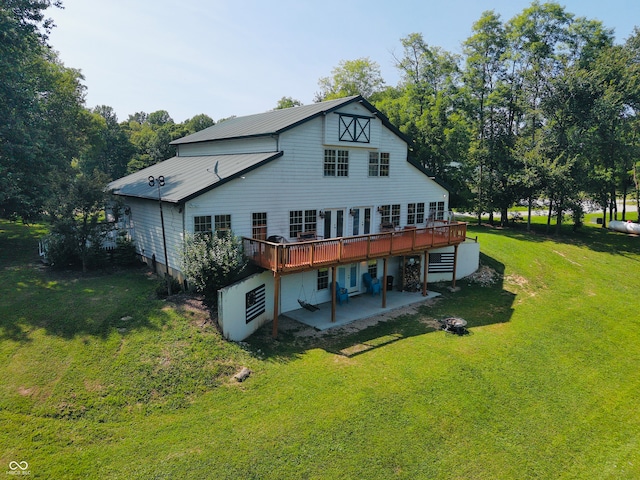 rear view of house featuring a wooden deck, a yard, and a patio