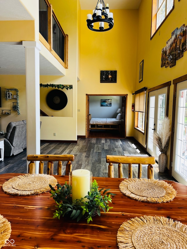 interior space featuring a high ceiling, dark hardwood / wood-style floors, and an inviting chandelier