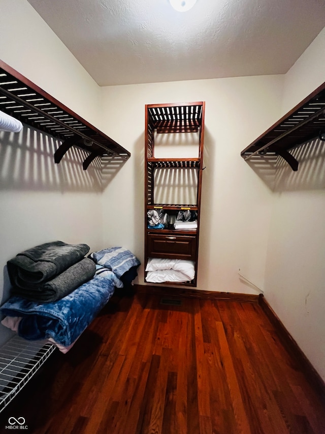 spacious closet featuring dark hardwood / wood-style flooring