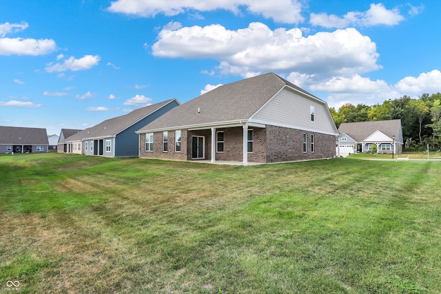 rear view of house with a lawn and a patio area