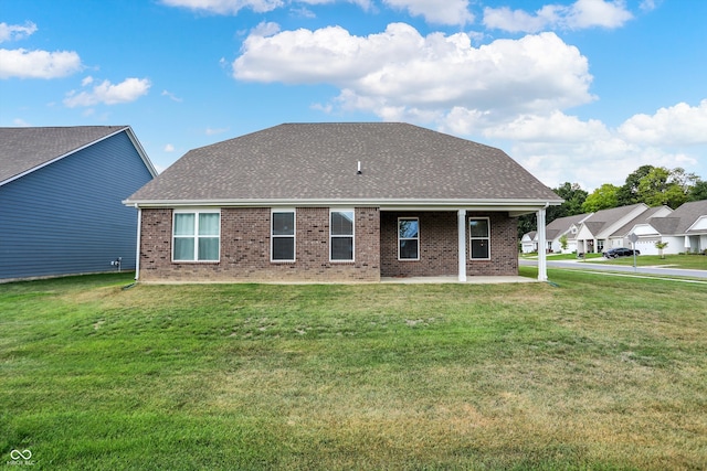 rear view of property featuring a lawn