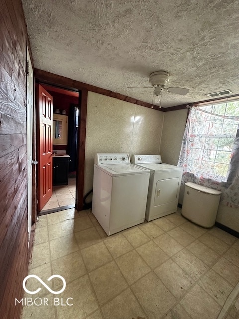 laundry area featuring crown molding, separate washer and dryer, wood walls, ceiling fan, and a textured ceiling