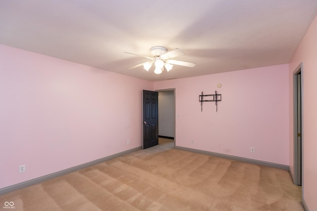 unfurnished room with light carpet, a ceiling fan, and baseboards