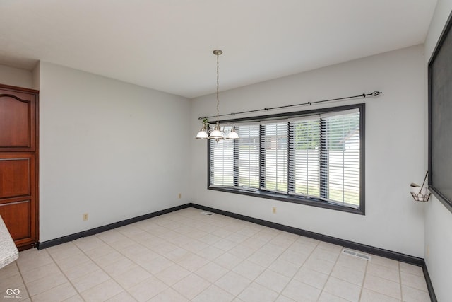 spare room featuring visible vents, baseboards, and a chandelier