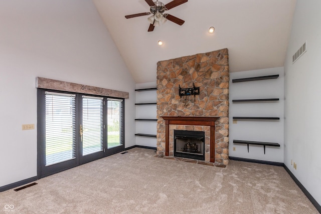 unfurnished living room with high vaulted ceiling, a stone fireplace, carpet flooring, and visible vents