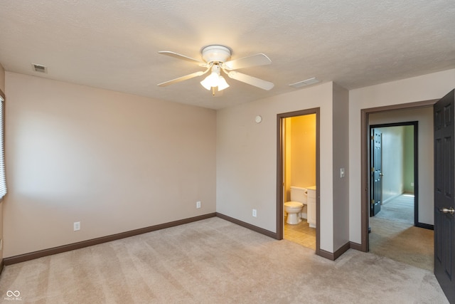 unfurnished bedroom featuring light carpet, a textured ceiling, visible vents, and baseboards